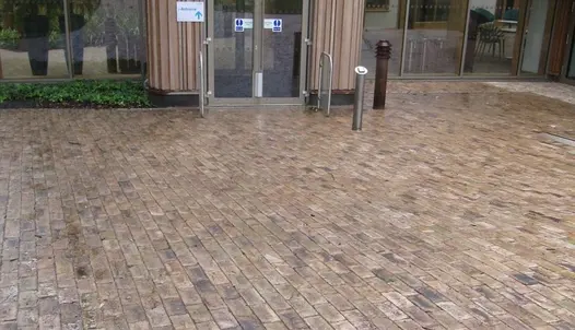 Huge area of walkway that leads to building, uses london mixture clay pavers. Seen wet and showing colour variations