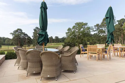Clubhouse terrace at sunset with curved limestone steps, outdoor seating and acid washed paving throughout.