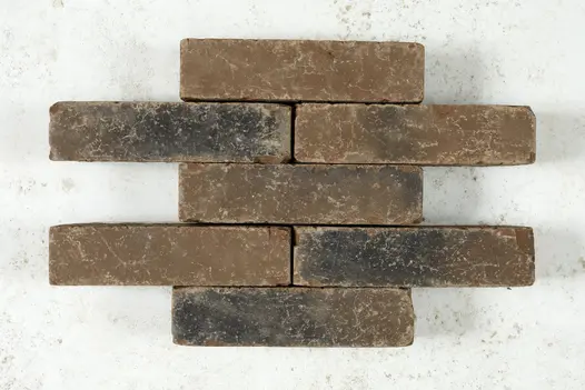 Seven Aldridge clay pavers laid out against a white background, emphasizing their uniformity and mellow colours.