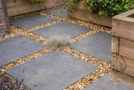 Anthracite Porcelain 800x800 paving slabs laid in a stepping-stone style with gravel joints.