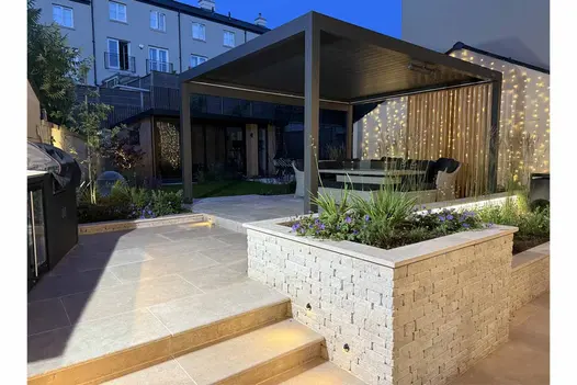 Antique Egyptian Beige limestone paving and wall copings in a modern garden with outdoor lighting and pergola