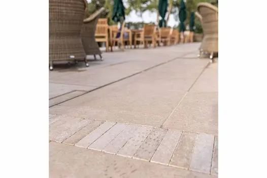 Antique Egyptian Beige Limestone Pavers inset between patio slabs near outdoor seating area at golf club.
