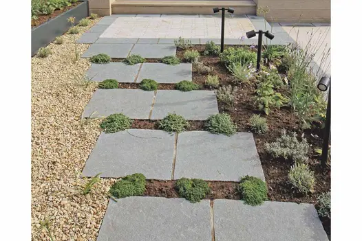 Stepping-stone path created using Antique Grey Limestone slabs, set among planting with gravel and Egyptian Beige Limestone detailing.