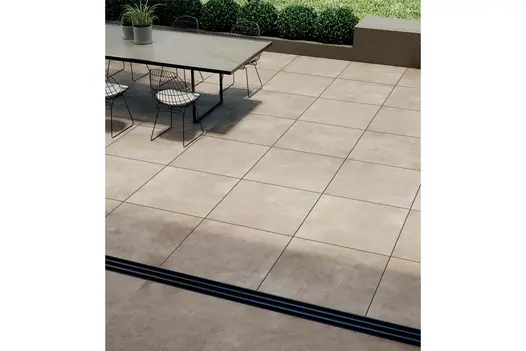 Looking out from a house onto an Area porcelain patio with a contemporary garden dining table and chair set.
