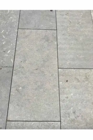Arezzo Grey Flamed Limestone paving shown laid with dark grout lines, showing off the stones textures and colours.