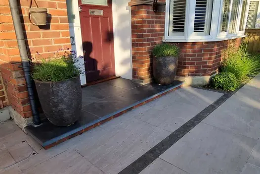 Open porch paved with Brazilian Black slabs and bullnose step treads treated with colour-enhancing sealant.