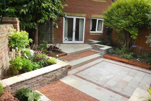 Traditional red brick house with corner back garden using mint sandstone, coping stones used on the raised walls.