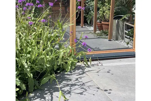 Threshold to a timber framed greenhouse paved with Anthracite porcelain with same paving continued into the greenhouse.