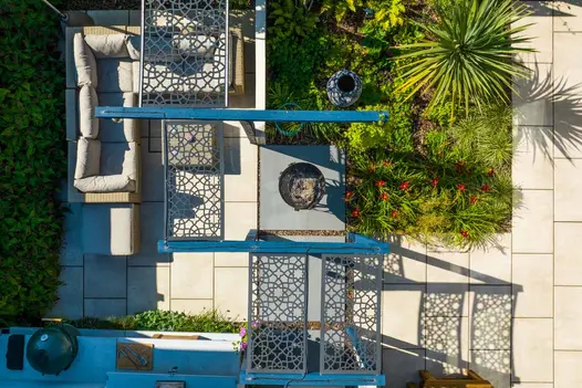 Bird's eye view of a garden design featuring Beige Sawn Sandstone Paving. These patio paving slabs create a striking feature around a firepit.