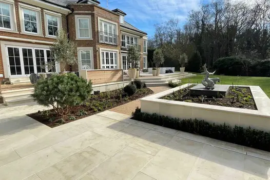 Large square raised bed, with central sculpture, capped with Beige Smooth Sandstone Coping Stones. Design by Kate Gould.