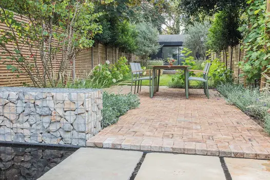Path of London Mixture Clay Paver Bricks used next to water feature with mint sandstone stepping stone. Caged rocks create copings.