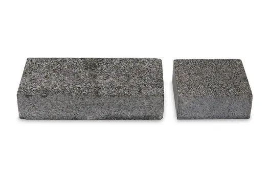 Professional photography showcasing one 200x100 and one 100x100 Sawn Black Granite sett next to each other on a white background.