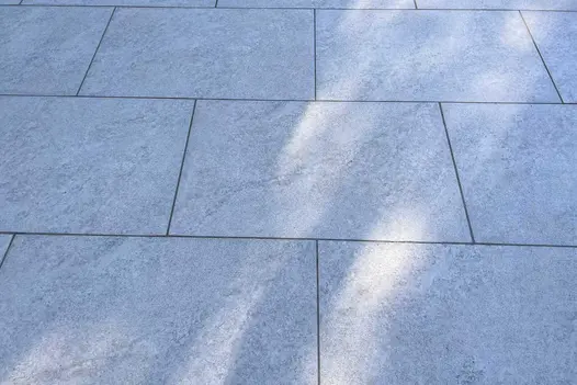 A detailed view of Astor Grey Porcelain Paving, showing its unique markings, complemented by dark grey grouting.