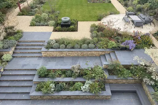 Multi-level garden with Brazilian Black Slate Bullnose Steps and stone retaining walls.