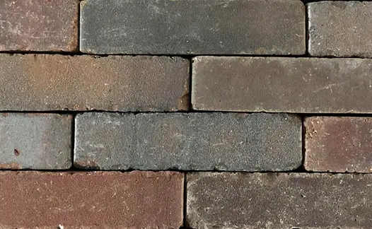 Close view of 10 Abbey Dark Multi clay pavers laid edge-on without sanded joints, showing tones of red and grey.