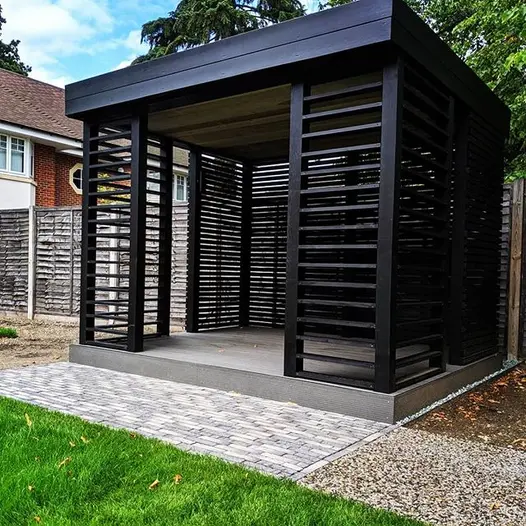 Japanese-style black wood pergola on decking plinth behind apron of Silver Grey Multi Clay Pavers . Built by Landmark Landscapes.