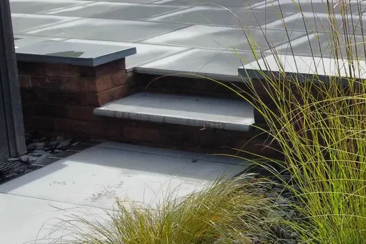 Close up shot of Florence Storm Porcelain 36mm Bullnose step leading up to wet patio in the same material.