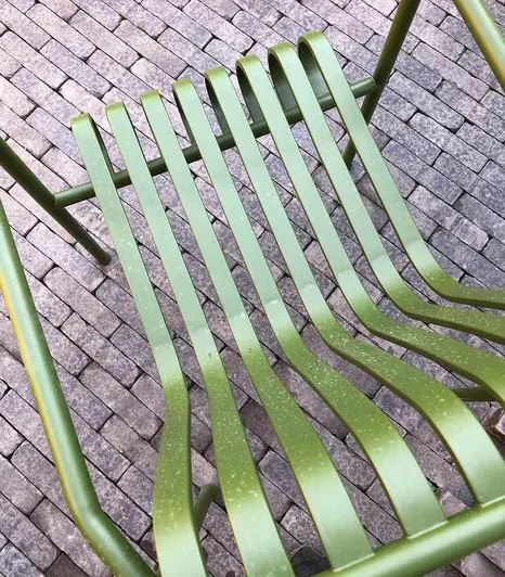 View through green metal garden chair shows patio of amersham clay pavers showing off its colour variation.
