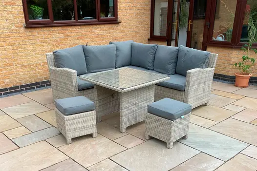 At back of house, french doors open onto Camel Dust Indian sandstone patio of varied sized slabs, with corner sofa set.