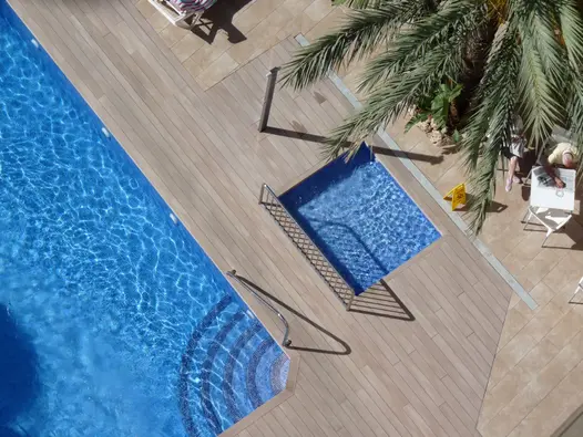 Aerial view of swimming pool and adjacent paddling pool set into large expanse of Cinnamon DesignBoard composite decking.