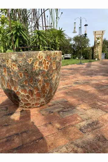 Rustic and aged plant pot displayed on top of Cotswold Clay Pavers shows off variation with colours and textures.