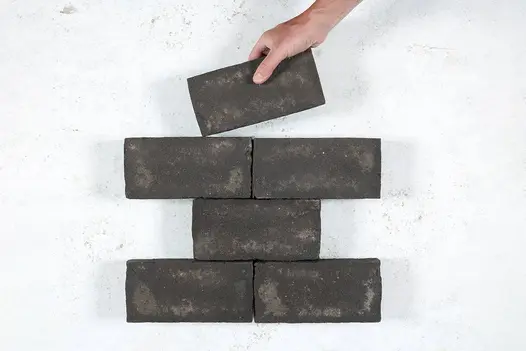 A hand places a brick on 6 Durham clay pavers, arranged in alternating layers of 1 and 2 bricks. Free UK delivery available.