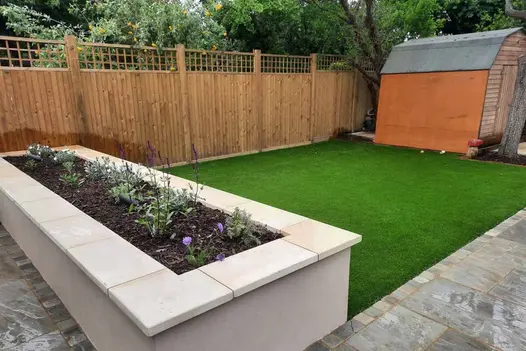 Harvest smooth sandstone coping stones used around raised flowerbed, showing off pencil round edges and colour variation.
