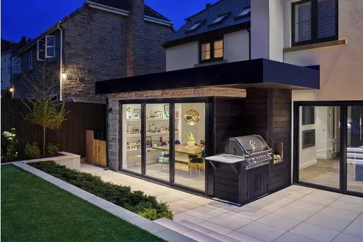 Rear extension with bi-fold doors leading to patio area paved with Comblanchien Porcelain Paving and steps from London Stone.