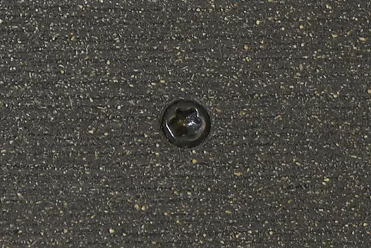 Charcoal composite decking board with Charcoal colour match screw fixed to the middle of the board.