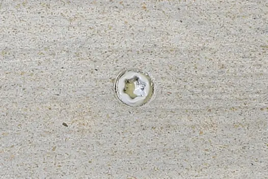 Silver composite decking board with Silver & Polar colour match screw fixed to the middle of the board.