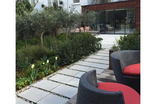 Pairs of Contemporary Grey sawn sandstone slabs laid next to each other create path with gravel joints. Design by Claire Mee.
