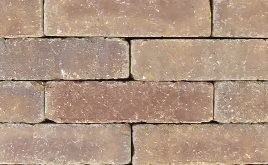Close view of Derby clay pavers laid running bond without sanded joints, showing brown tones, white flecks and tumbled edges.