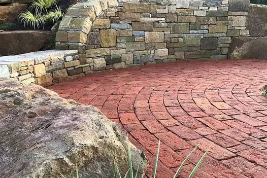 Circle design of Dorset antique clay pavers enclosed by large rock wall showing close ups of the Belgian bricks variation and texture.
