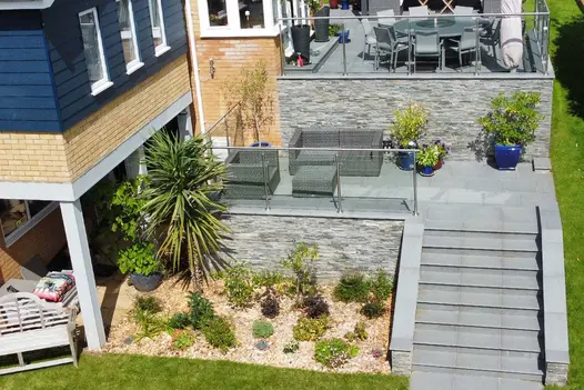Birds eye view of Trendy Black Porcelain paving, steps and copings. Glass panels surround multi-level impressive patio.