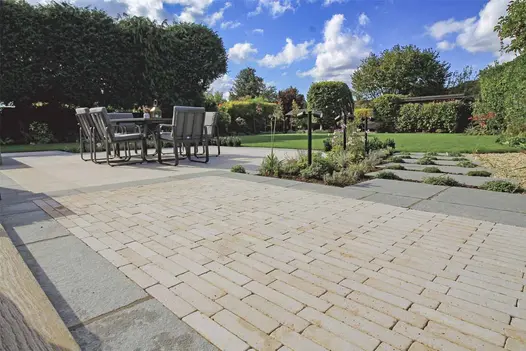 Egyptian Beige Limestone Pavers used as a central patio feature, bordered with Antique Grey Limestone and surrounded by modern garden planting.