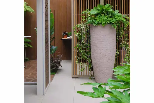 Egyptian Beige Porcelain Paving laid alongside a tall textured planter and vertical timber screening at RHS Chelsea garden.