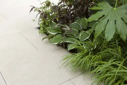 Egyptian Beige Porcelain slabs paired with lush planting in a light-toned courtyard garden by Garden House Design.