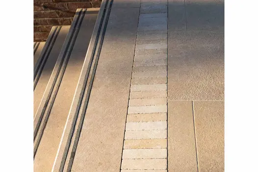 Close-up of acid washed limestone step detail with contrasting grip inserts and linear pale stone feature strip.