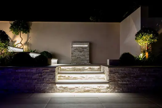 2 high walls faced with Hydra Beige DesignClad external cladding make boundary of flight of steps with landing at right-angled turn.