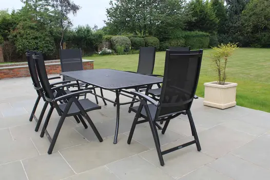 Large garden, mainly laid to grass, with patio of Heath sawn sandstone paving slabs with pale joints. Brick raised bed down one side.