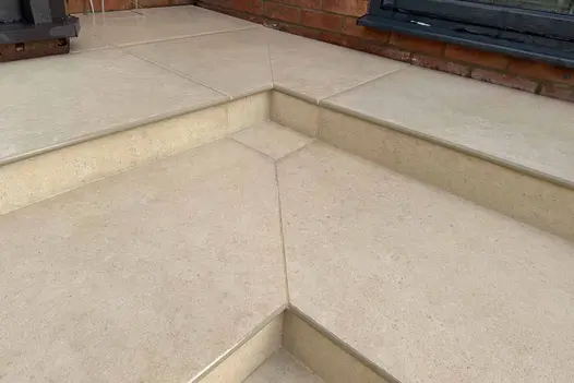 Close-up of Florence Beige 20mm Bullnose Step showing smooth texture and neat installation against brick wall.