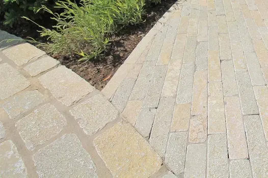 Flowpoint Natural Grey jointing used on curved pathway laid with pale yellow and grey limestone cobbles.