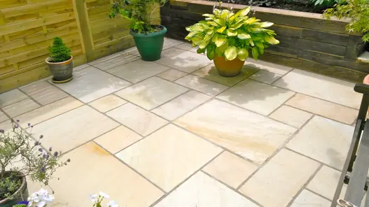3 pots on small Mint Indian sandstone patio of project pack paving, laid with wide joints making feature of different slab sizes.