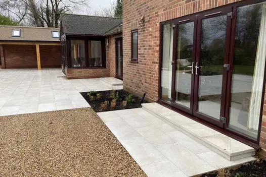 Gea Porcelain 40mm Steps at door threshold alongside gravel and clay pavers.