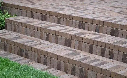 Close-up of Aldridge clay pavers being used to clad three steps, highlighting their durability and natural edges.