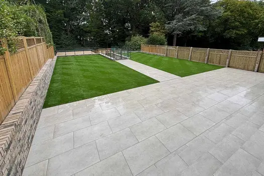 Elevated garden view with large Grey York Porcelain patio, central path and formal lawn arrangement.