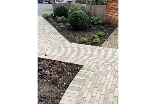 Gromo Antica brick paving runs from street, between planted beds, up front garden to meet matching path coming in at a right angle.