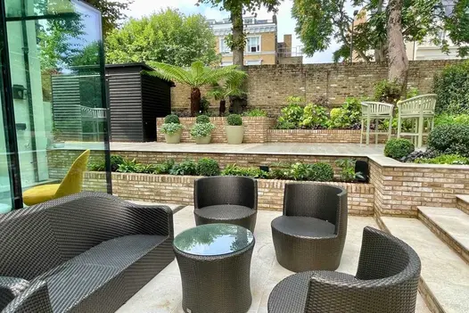 Garden on 2 levels, laid with Gea porcelain paving. Retaining walls and step risers in brick. Built by Hampstead Garden Design.
