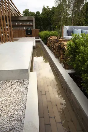 laid underwater and running to bbq area, gromo antica clay pavers used as water feature next to light coloured patio.