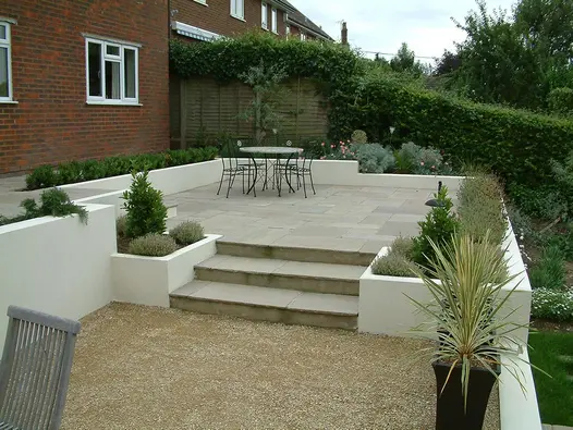 two steps of raj green indian sandstone step up to patio in the same material with metal dining table.